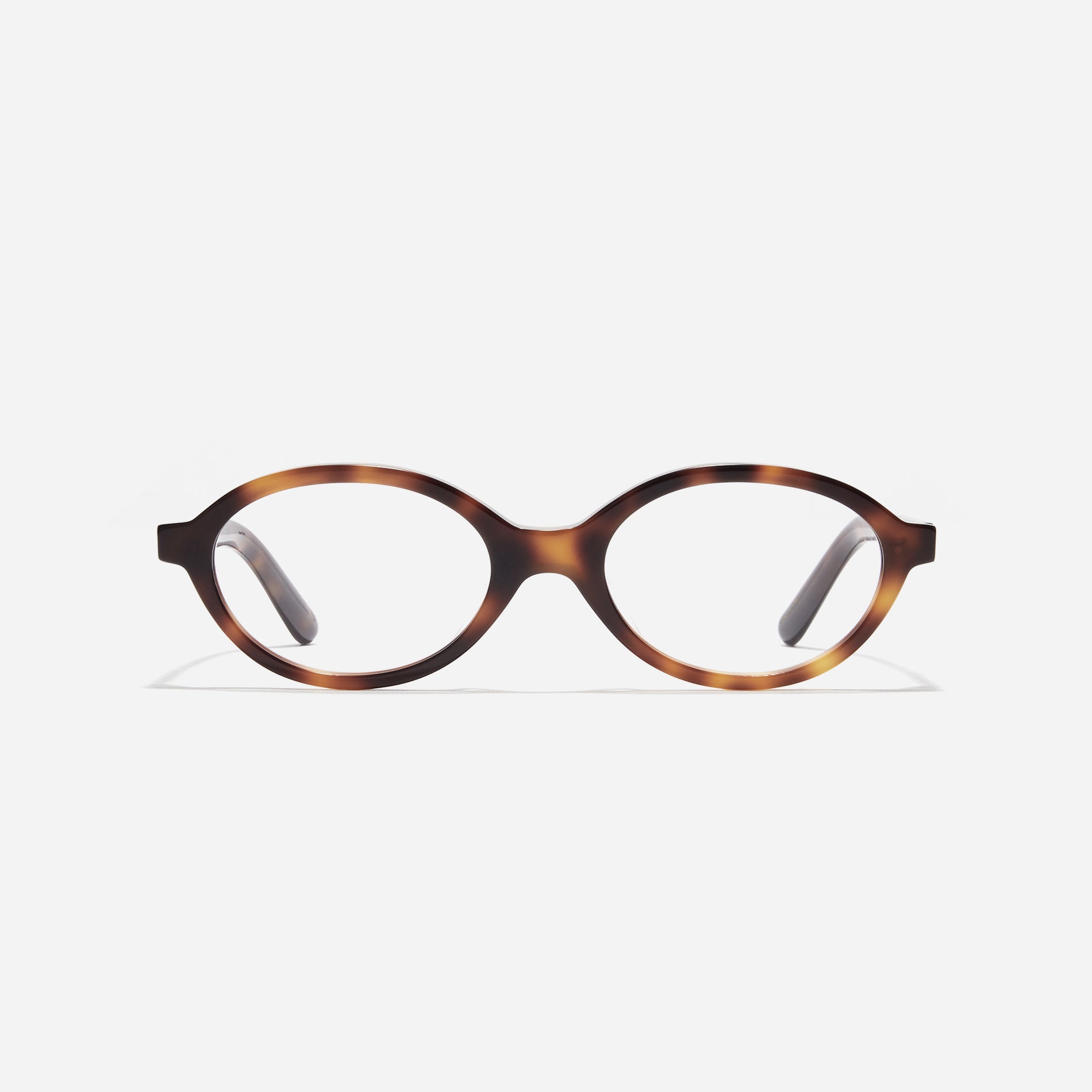 Compact, oval-shaped horn-rimmed eyeglasses featuring a narrow rim and bold frame. Their design captures a modern reinterpretation of 90s retro vibes, providing a trendy and stylish look.