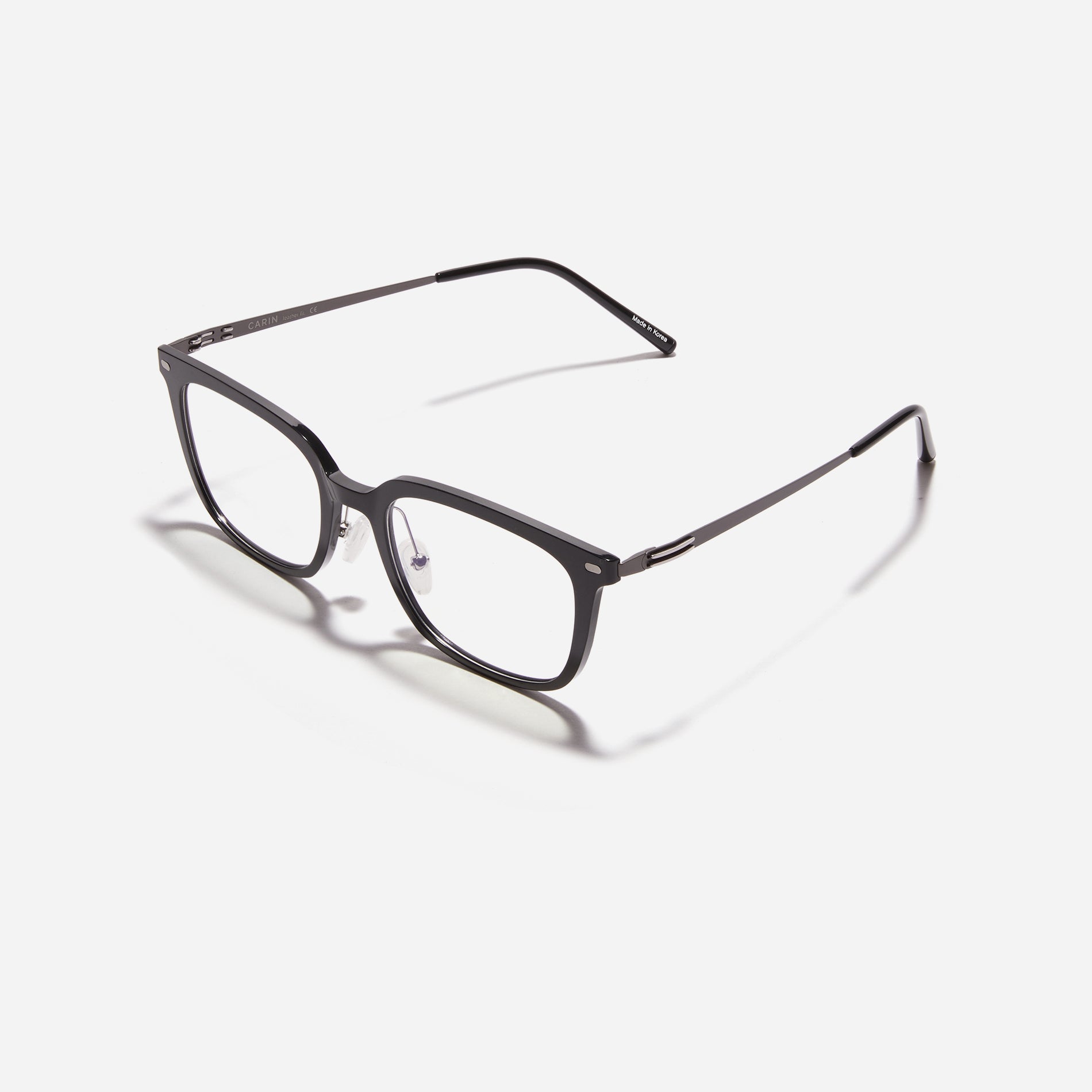Square-shaped combination eyeglasses from CARIN's 'Feather Fit' line. Their combination frame seamlessly blends bio-plastic and titanium, utilizing advanced injection molding technology, often seen in the manufacturing of cell phones and watches.
