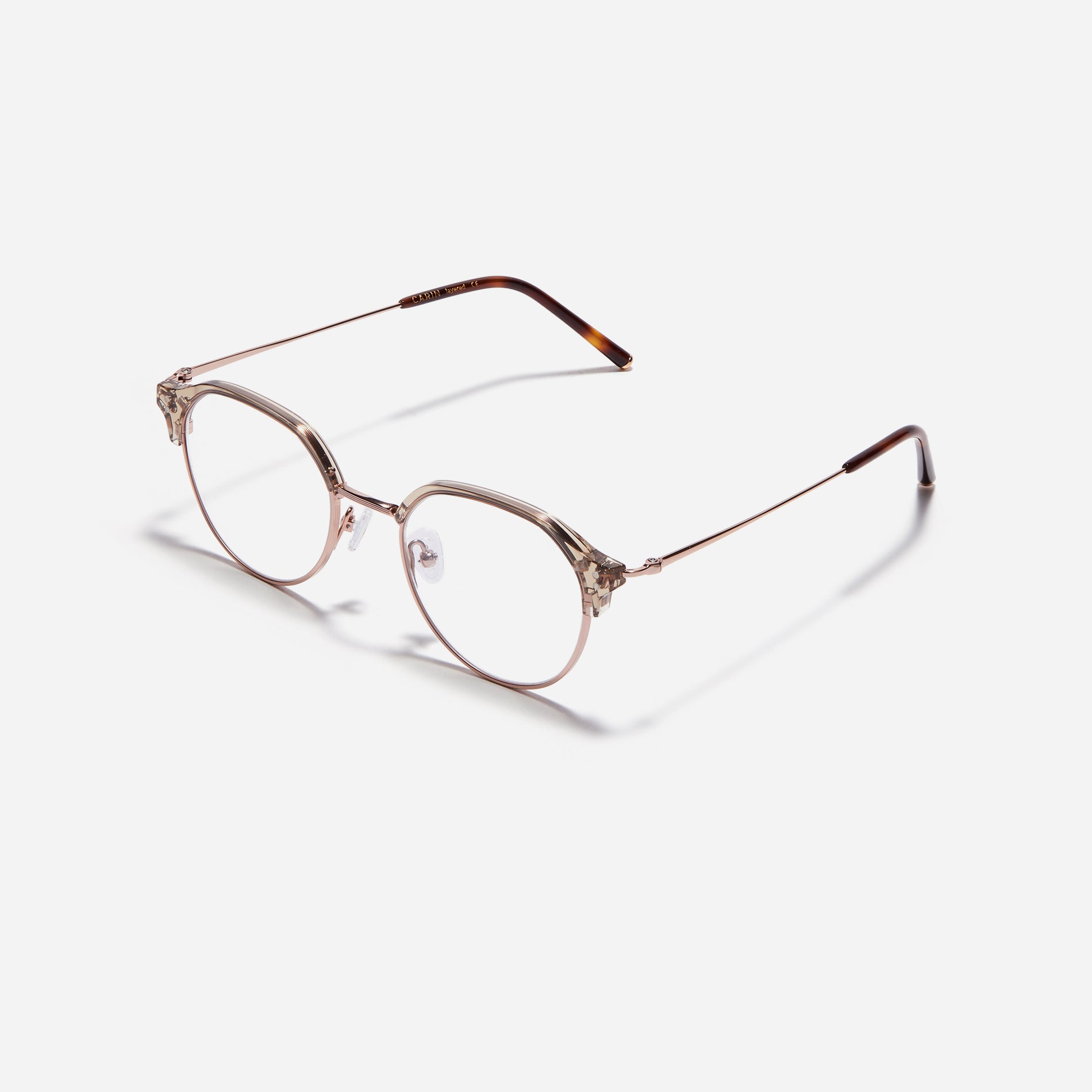 Polygonal-shaped gold-rimmed eyeglasses. The frame, constructed from bioplastic and titanium, seamlessly merges exceptional durability with an ultra-lightweight build, while stylish nose bridge lining details enhance the overall design. The B-titanium temples deliver a lightweight and comfortable fit, guaranteeing prolonged wear without any discomfort.