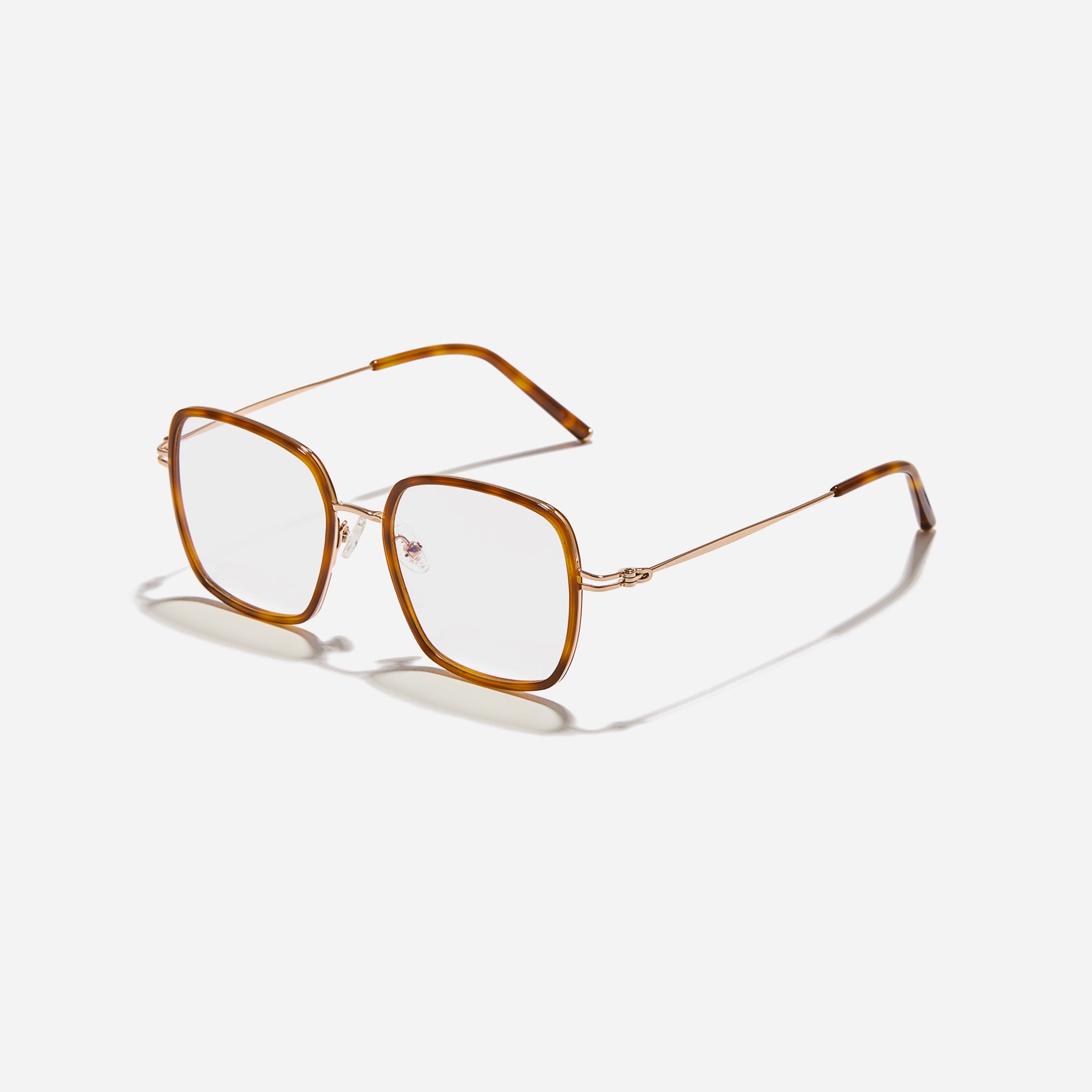 Rectangular-shaped oversized eyeglasses characterized by a delicate acetate rim that secures the frame and hinge details. The slim temples, made from lightweight and elastic B-Titanium material, ensure a consistently comfortable fit.