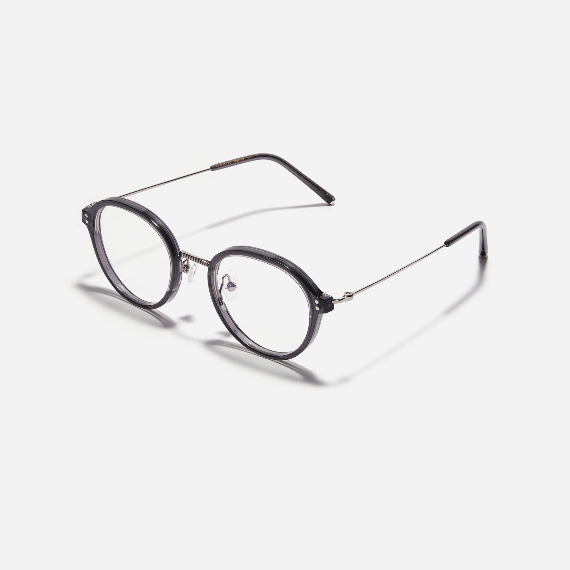 Round-shaped eyeglasses with a dual-combi structure inspired by from the aesthetics of platform shoes. Their dual-rim structure seamlessly accommodates thick lenses for higher prescriptions, while retro vibes are accentuated by side color accents.